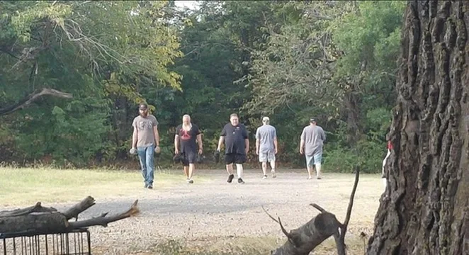 Men of The Refuge training together outdoors with weights.