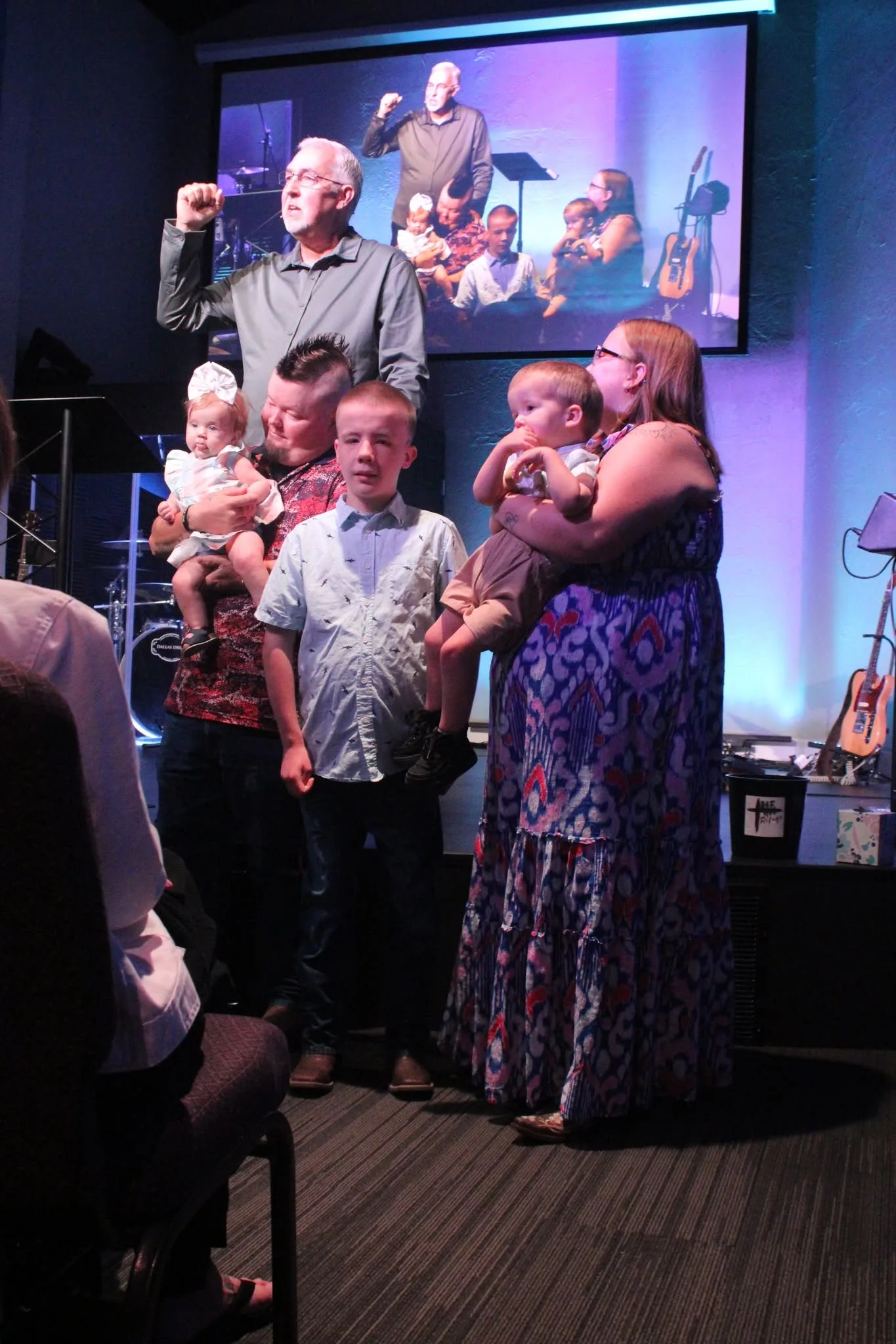 A family dedicating their daughter on stage at The Refuge.