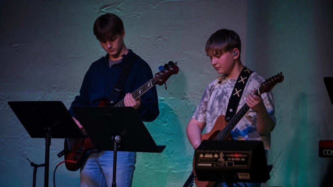 Two Refuge Youth musicians playing guitar and bass during worship.